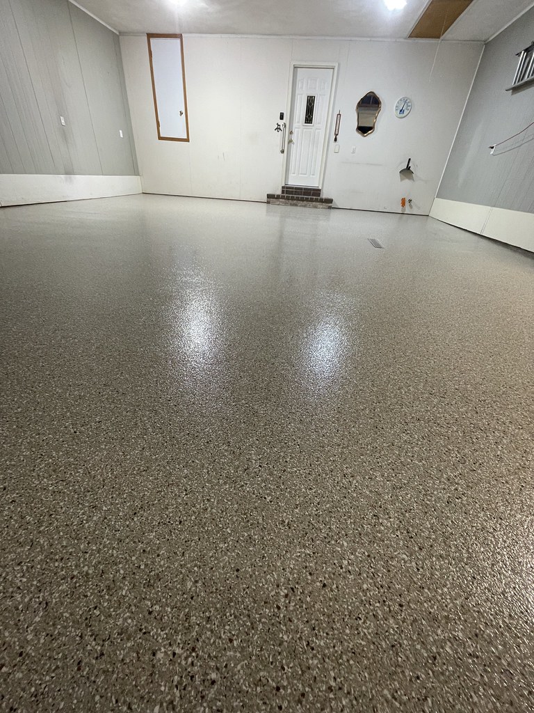 The newly coated garage floor with a smooth, speckled finish