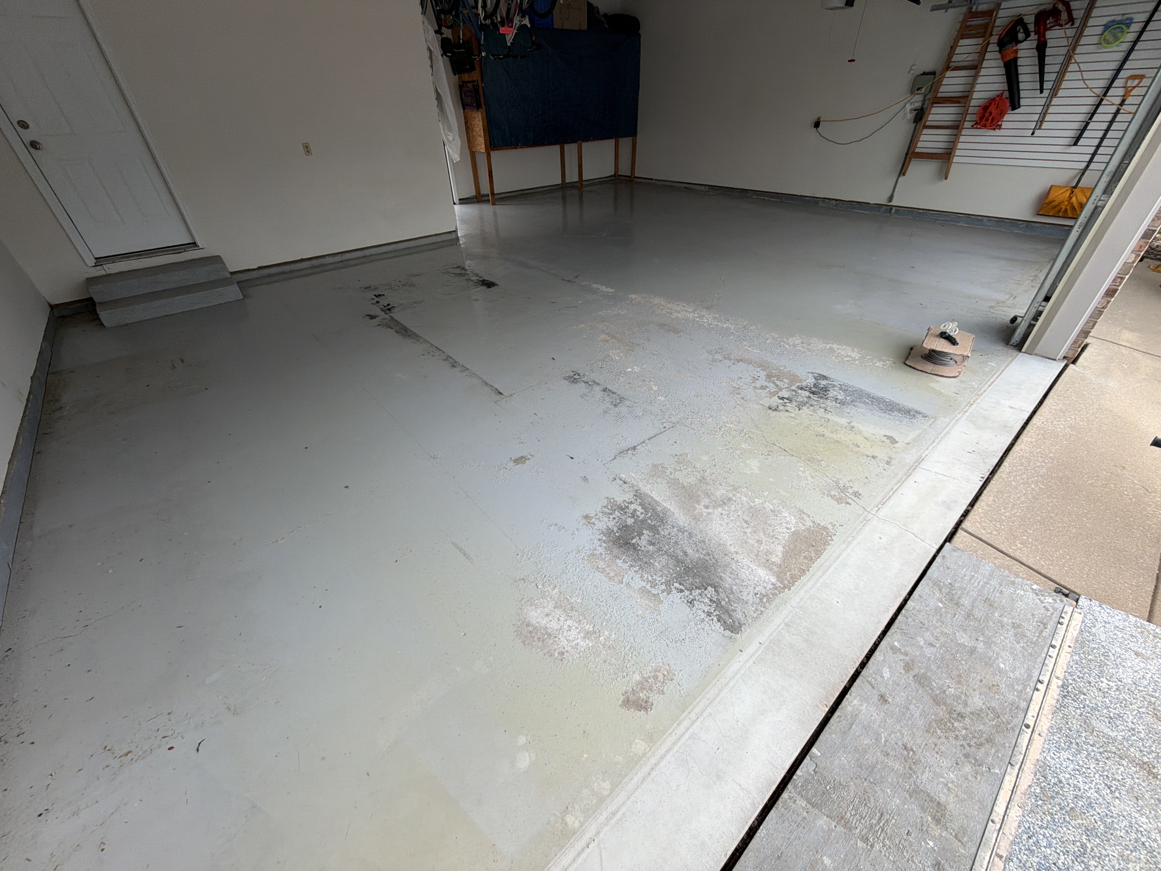 Old, stained concrete garage floor in Bloomington before coating