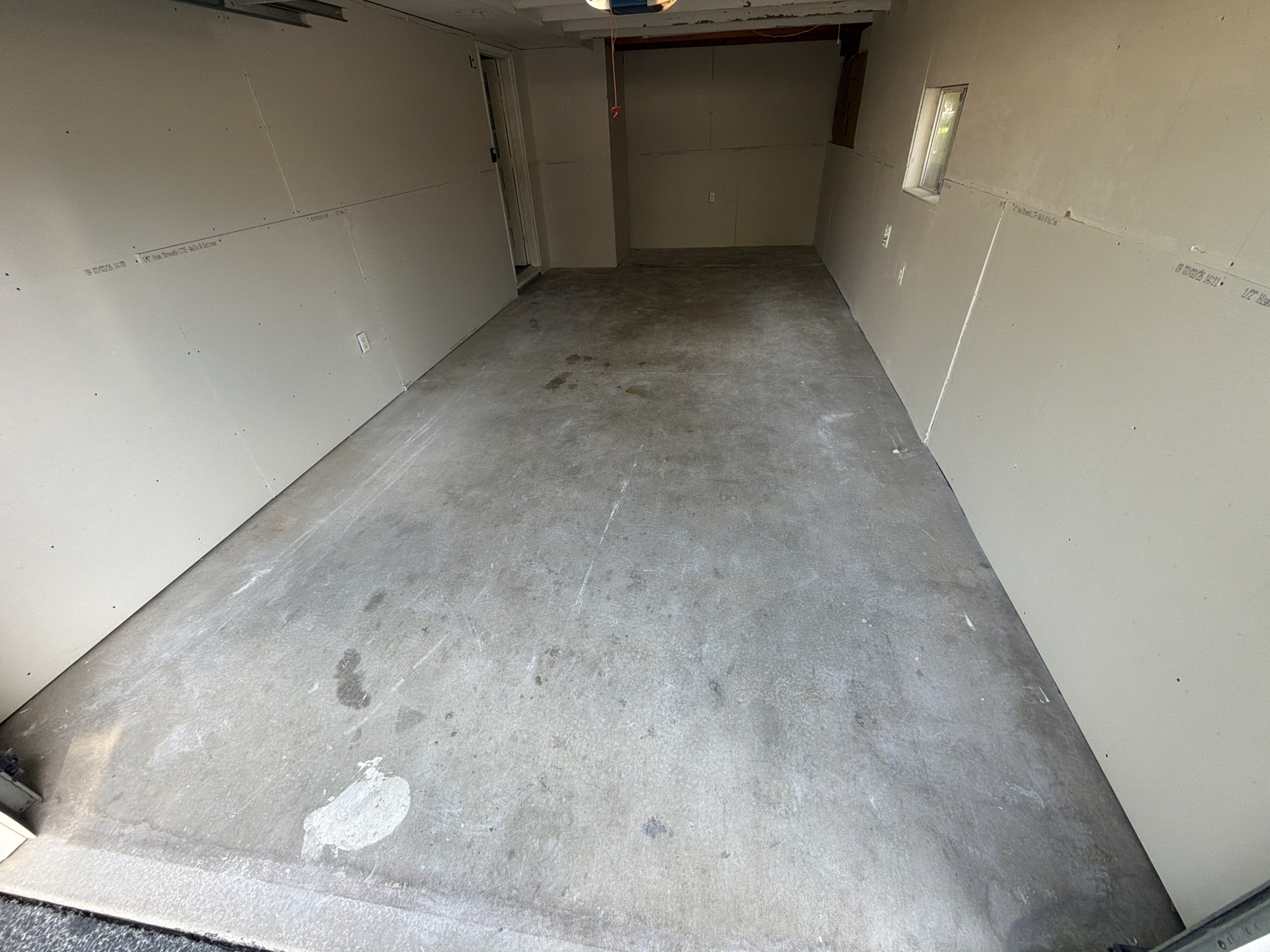 Pre-inspection photo of Lonnie's garage floor, showing areas of discoloration and general signs of aging concrete.